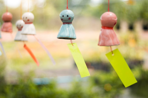 The smiling face doll made of ceramic is swaying in the wind