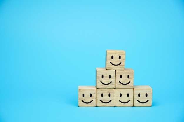 Smiling face icons on wooden cubes Business service rating customer satisfaction or teamwork