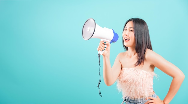 웃는 얼굴 초상화 아시아 아름다운 여성 파란색 배경에 확성기를 사용하고 텍스트 복사 공간