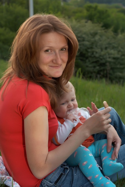 Smiling faces of mother and her baby walking outdoor