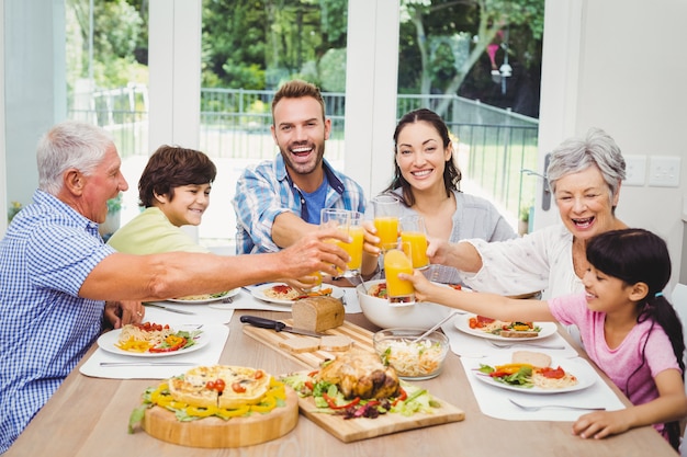 Smiling family clinking with juice glass