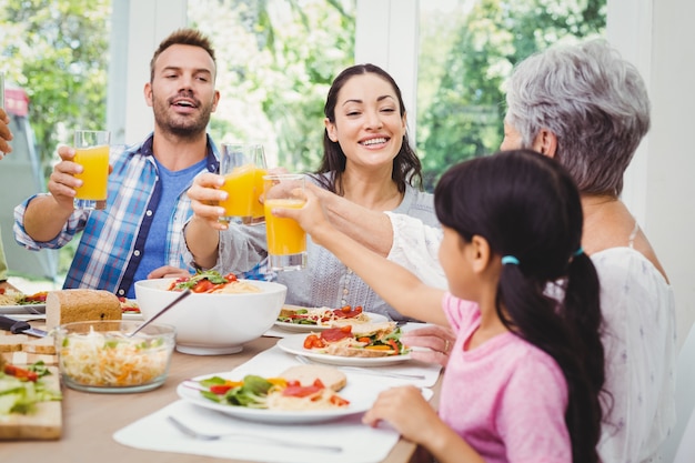 Smiling family clinking with juice glass