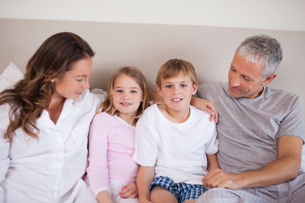 Smiling family lying on a bed