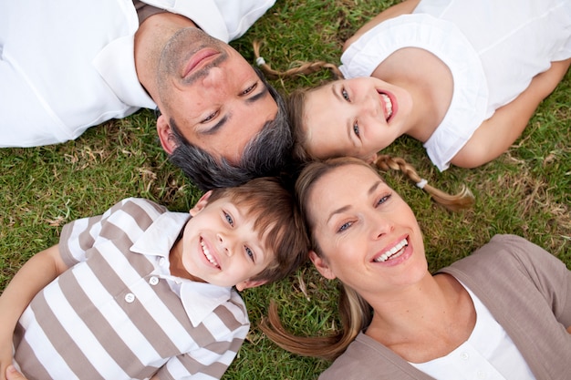 Smiling family lying in a park