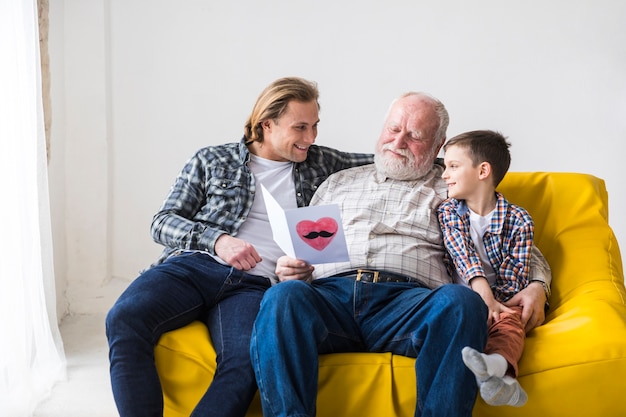 Photo smiling family of men hugging on couch