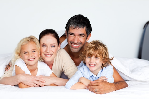 Smiling family together on bed