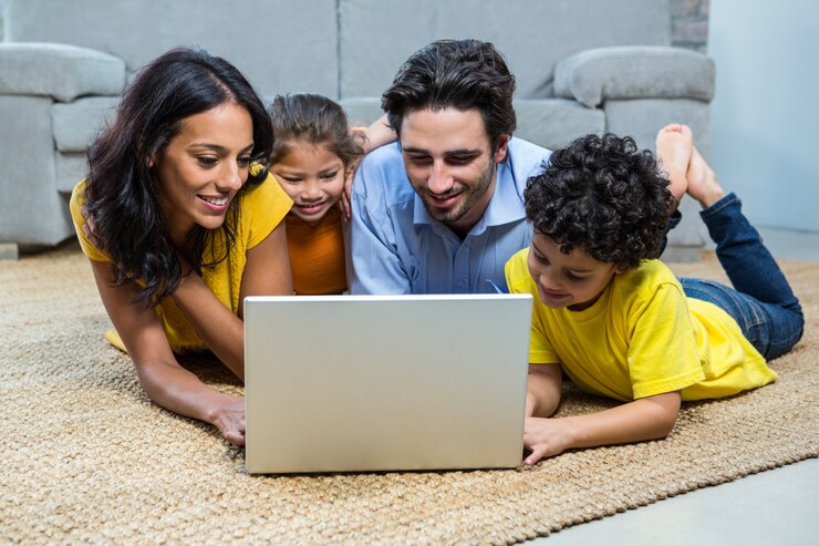 Photo smiling family using laptop in living room