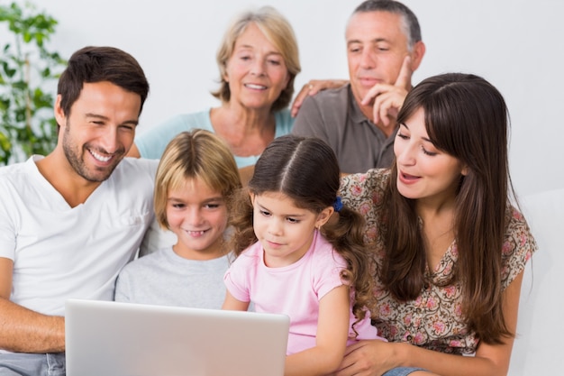 Smiling family watching something on laptop