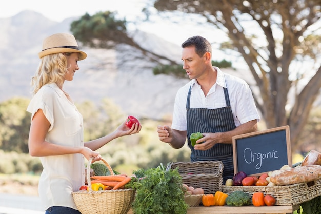 Agricoltore sorridente che discute con un cliente biondo