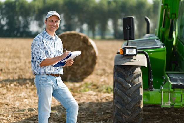 Smiling farmer writing on a document