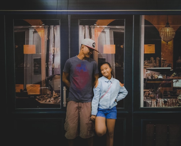 Фото Улыбающиеся отец и дочь стоят перед магазином