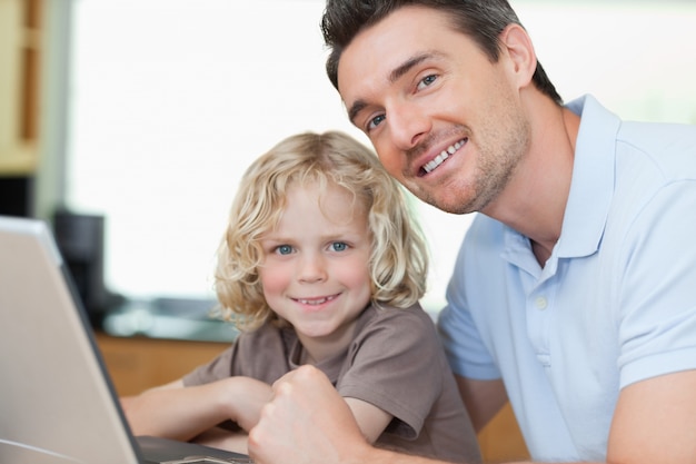 Smiling father and son with notebook