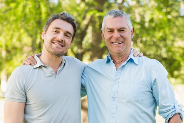 Padre sorridente con figlio adulto al parco