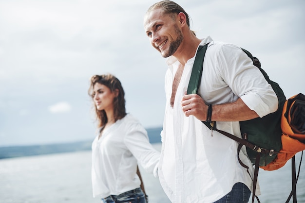 Smiling and feeling happy. Cheerful walk of lovely couple on the outdoor at lake background