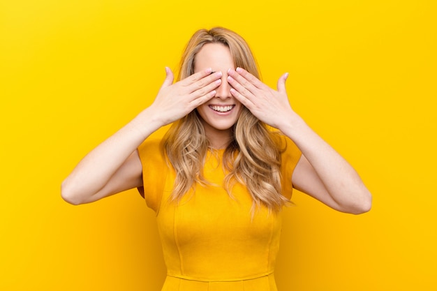 Sorridendo e sentendosi felice, coprendo gli occhi con entrambe le mani e aspettando un'incredibile sorpresa