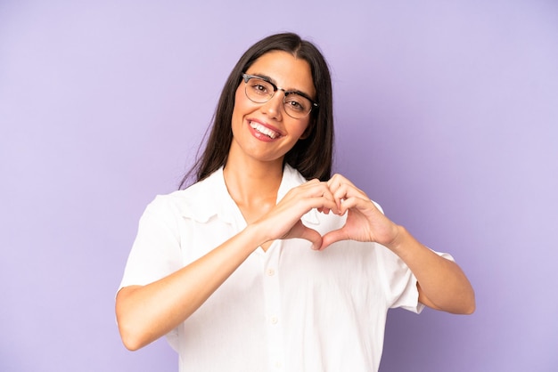 Sorridendo e sentendosi felice carino romantico e innamorato a forma di cuore con entrambe le mani