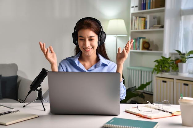 Photo smiling and feeling positive. young asian businesswoman student teacher tutor wear wireless headset video conference calling on laptop computer talk by webcam learn teach in online chat. young asian w