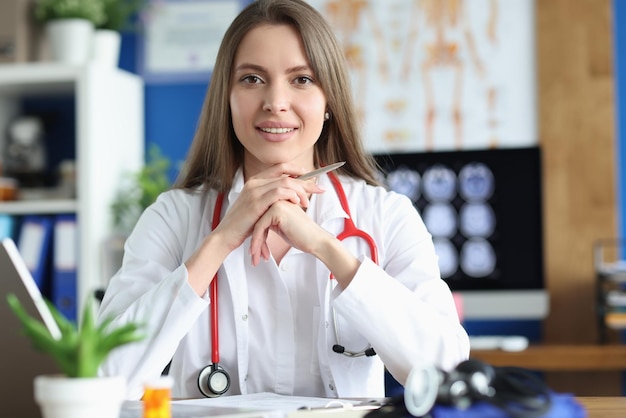 클리닉에서 일하는 가운 젊은 의료 전문가의 웃는 여성 의사