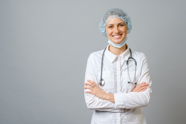 Medico femminile sorridente in camice da laboratorio con le braccia attraversate