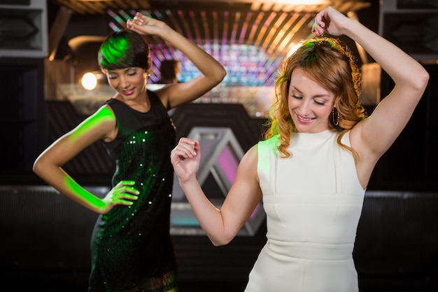 Photo smiling female friends dancing on dance floor