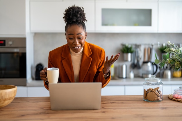 smiling female professional discussing business ideas over video call on wireless computer at home
