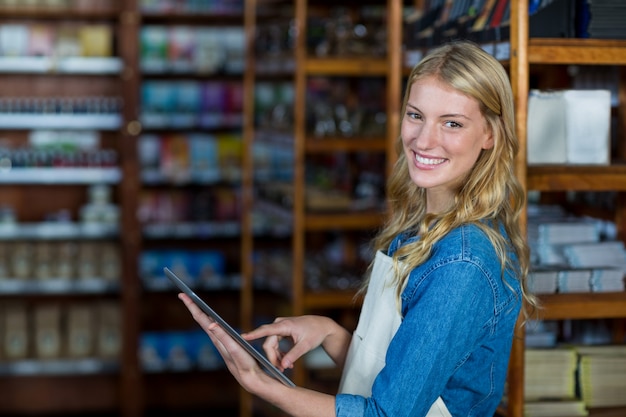 슈퍼마켓에서 디지털 태블릿을 사용하여 여성 직원 미소