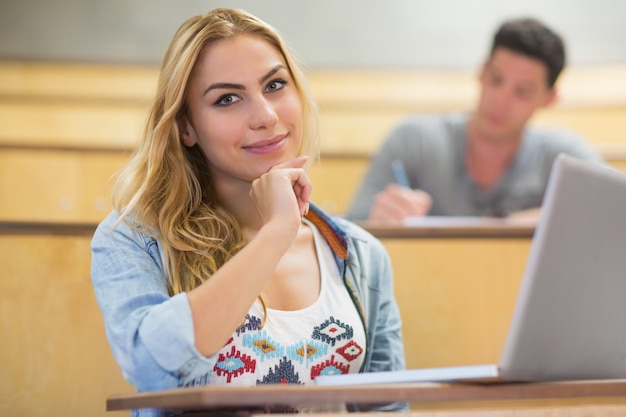 講堂での授業中に笑顔の女子学生