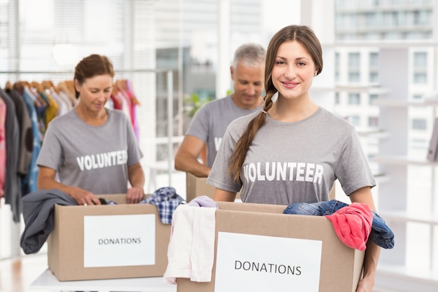 Volontario femminile sorridente che trasporta casella di donazione