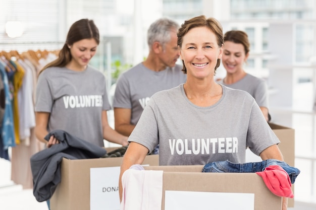 Photo smiling female volunteer carrying donation box