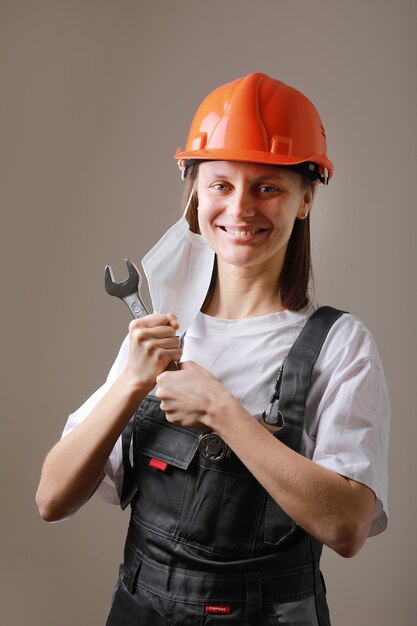 smiling female worker holding a wrench for adjust