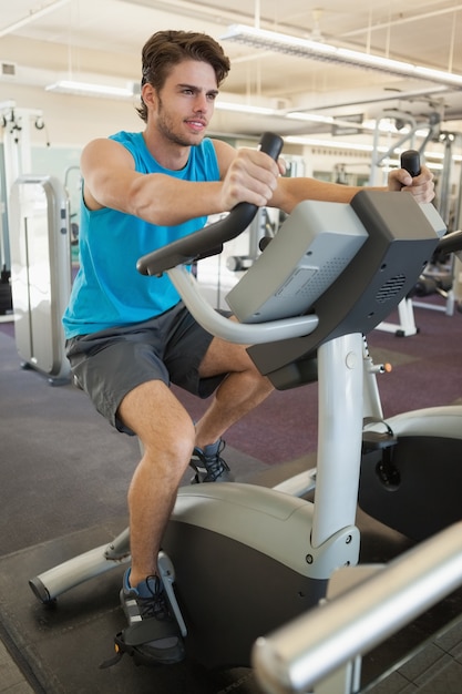 Smiling fit man on the exercise bike