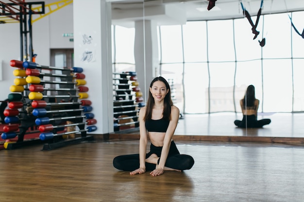 Smiling fit woman sitting in gym