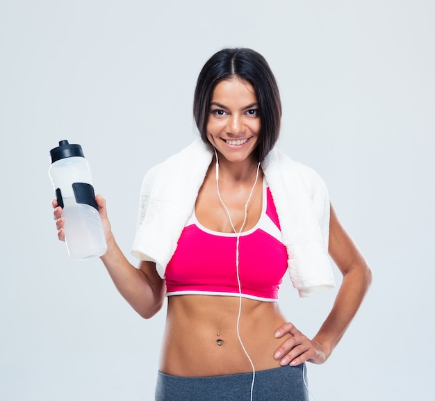 Smiling fitness woman holding bottle with water