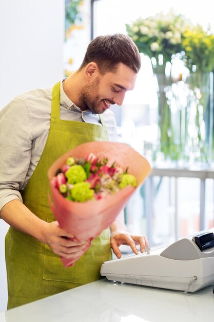 Foto uomo fiorista sorridente con un gruppo al negozio di fiori