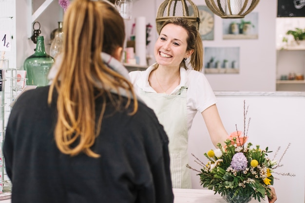 Foto fiorista sorridente che parla con il cliente