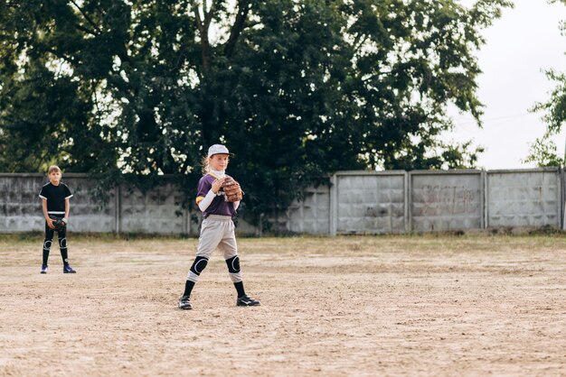 野球ユニフォームを着た笑顔の女の子が試合の準備をしています。野球トレーニング