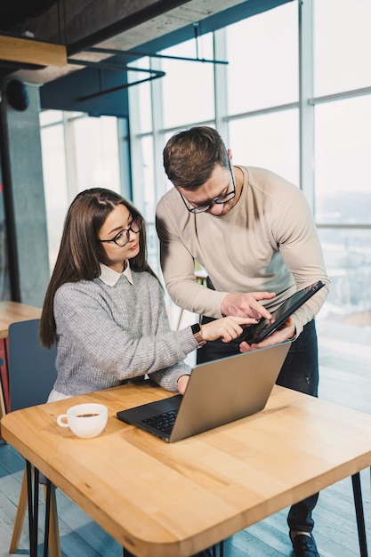 Una donna d'affari freelance sorridente che lavora a un nuovo progetto sul portatile il concetto di lavoro delle persone d'affare un moderno ufficio caffè per il lavoro remoto e online con internet