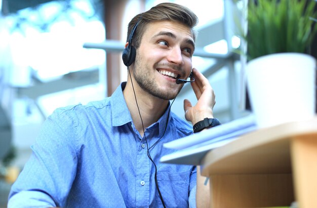 Foto operatore di call center maschio giovane bello sorridente amichevole.