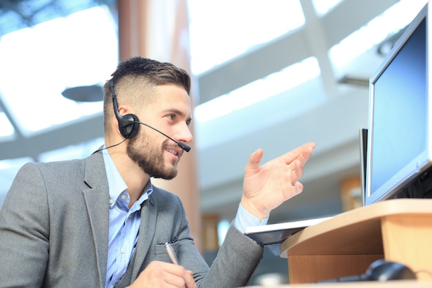 Photo smiling friendly handsome young male call centre operator.