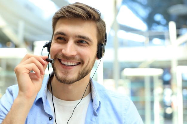 Smiling friendly handsome young male call centre operator.