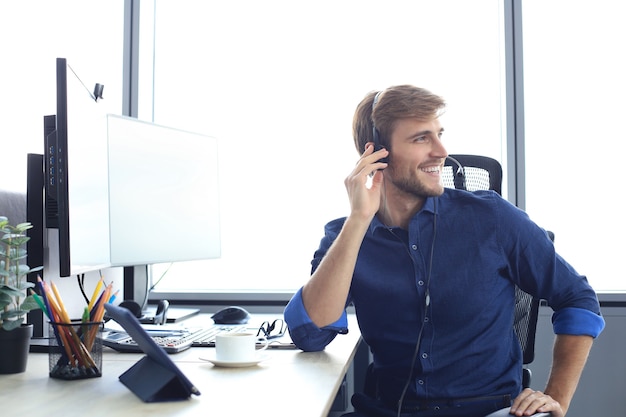 Smiling friendly handsome young male call centre operator.