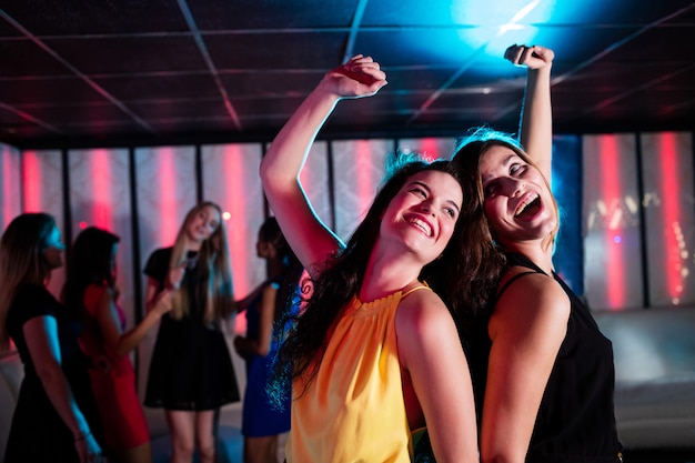 Smiling friends dancing on dance floor