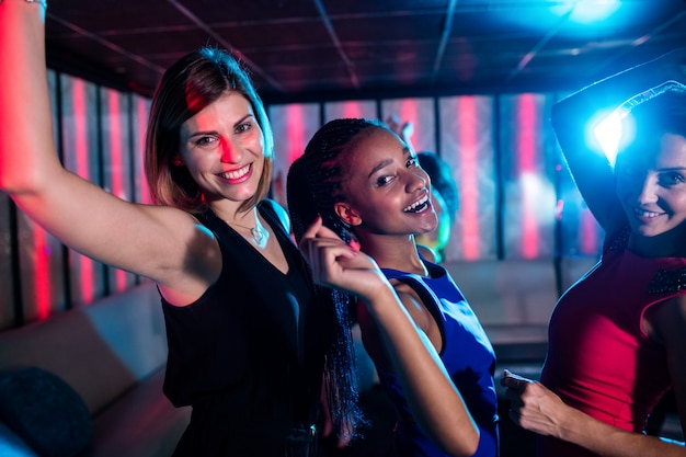 Premium Photo | Smiling friends dancing on dance floor