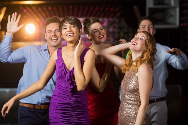 Smiling friends dancing on dance floor