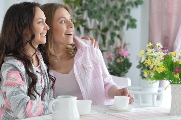 Smiling friends drinking tea