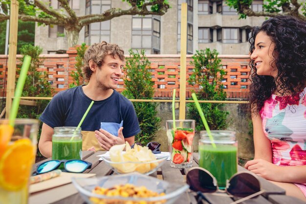 Smiling friends having food and drink at restaurant