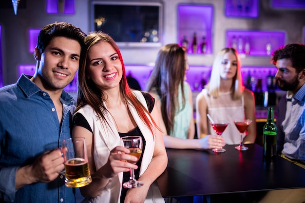 Smiling friends having a glass of wine and beer in bar