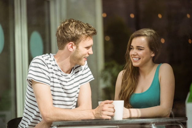 Smiling friends holding mug of coffee