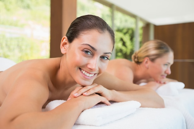 Smiling friends lying on massage tables