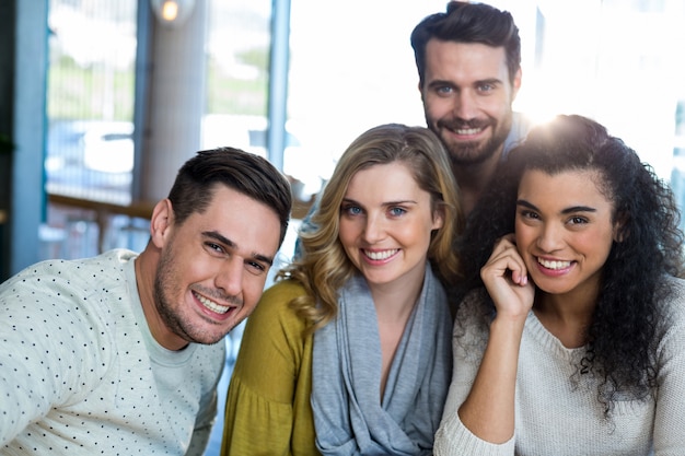 Smiling friends posing in cafe